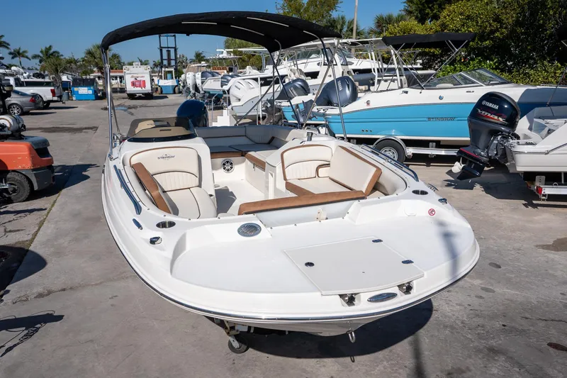 Slide: The Image of 2024 Stingray 192 SC boat with seating, docked in a marina under sunny skies. - 1
