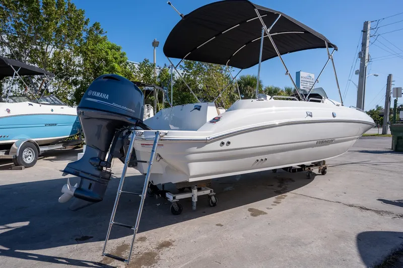 Slide: The Image of 2024 Stingray 192 SC boat with Yamaha outboard motor and canopy, parked outdoors. - 3