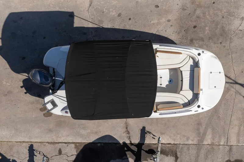 Slide: The Image of Overhead view of 2024 Stingray 192 SC boat with black canopy on concrete surface. - 6