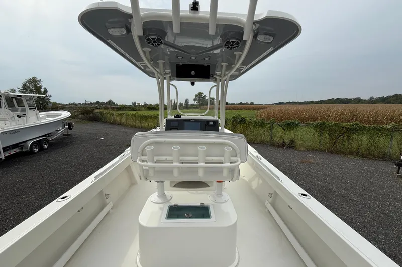Slide: The Image of 2024 Parker 2300 Special Edition boat interior with console and seating, parked outdoors. - 10