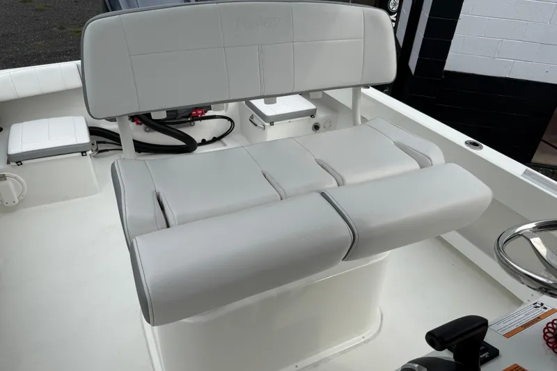 Slide: The Image of 2024 Parker 2300 Special Edition boat interior with cushioned seating and steering wheel. - 19