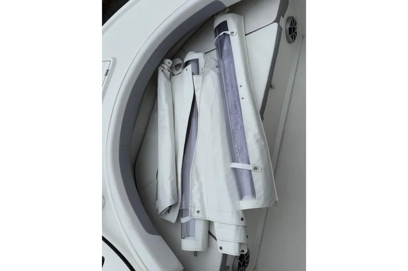 Slide: The Image of 2024 Parker 2300 Special Edition boat interior storage compartment with rolled-up covers. - 22