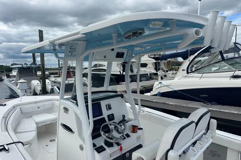 Slide: The Image of 2020 Sea Pro 259 Sport boat docked, featuring a modern helm and seating area. - 7