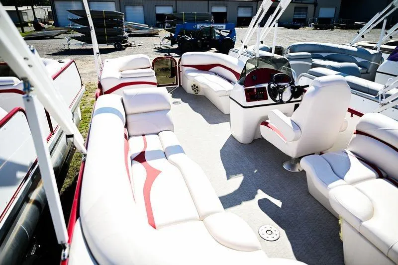 Slide: The Image of 2023 Aloha Pontoon Mahalo 23 interior with white and red seating, steering console, and open deck. - 7