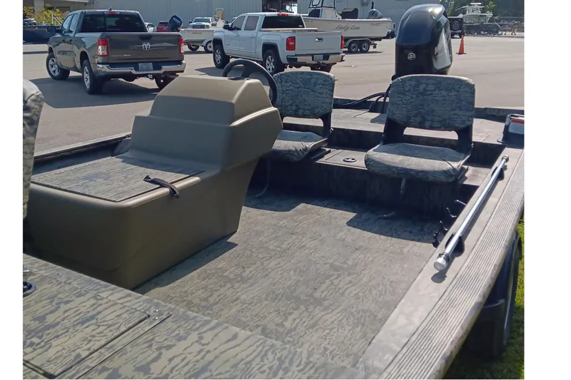 Slide: The Image of 2026 Tracker Grizzly 1754 SC boat interior with camouflage seating and steering console. - 10