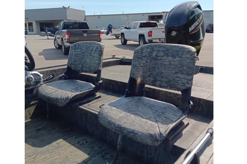 Slide: The Image of 2026 Tracker Grizzly 1754 SC boat interior with camo seats and Mercury outboard motor. - 11