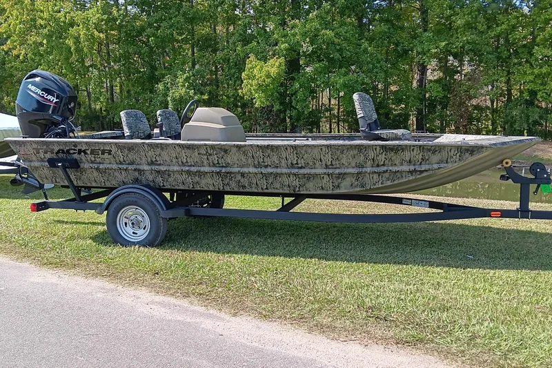 Slide: The Image of 2026 Tracker Grizzly 1754 SC boat on trailer, camo design, parked on grass. - 3