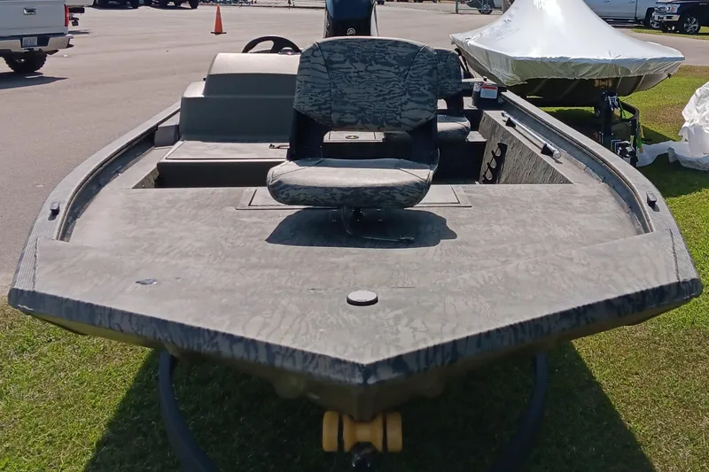 Slide: The Image of 2026 Tracker Grizzly 1754 SC boat with camouflage seating, displayed outdoors. - 6