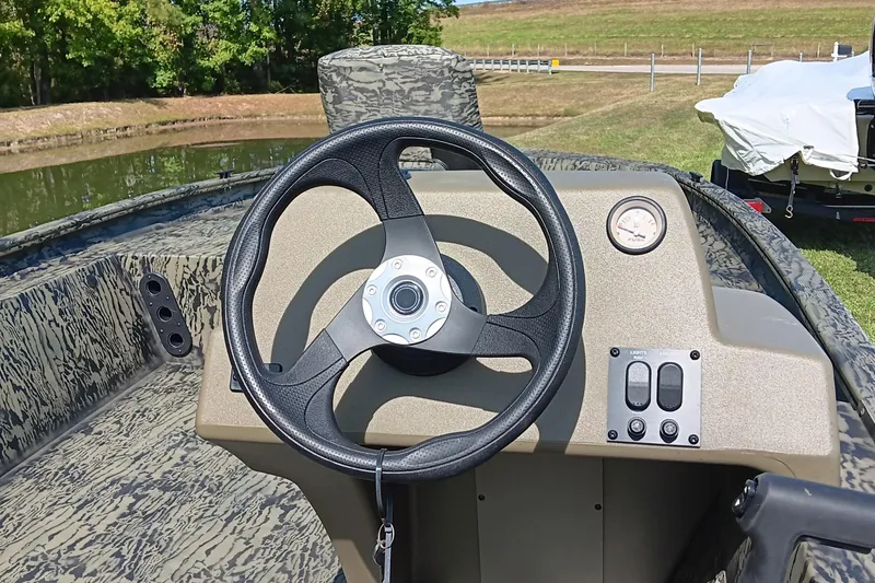 Slide: The Image of 2026 Tracker Grizzly 1754 SC boat dashboard with steering wheel and controls. - 9