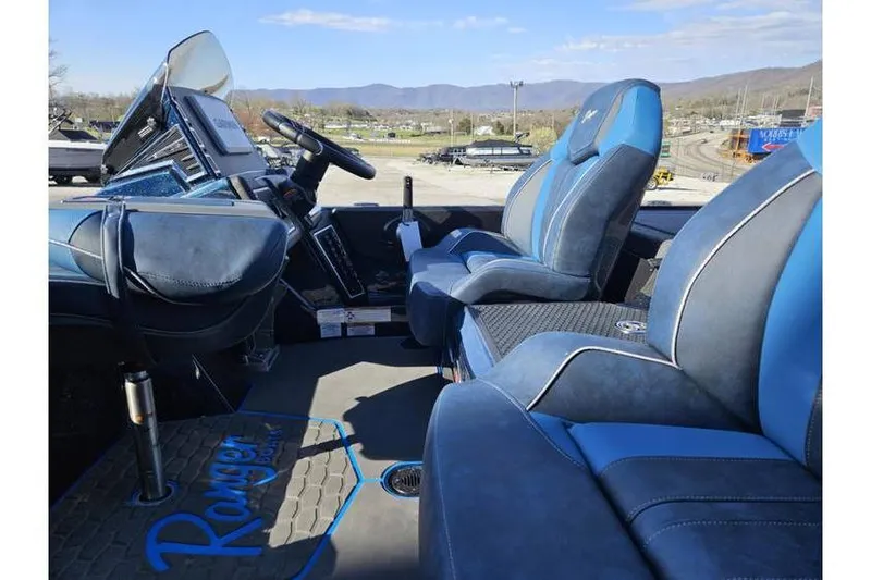 Slide: The Image of 2025 Ranger Z519 Garmin Ranger Cup boat interior with blue seating and steering console. - 7