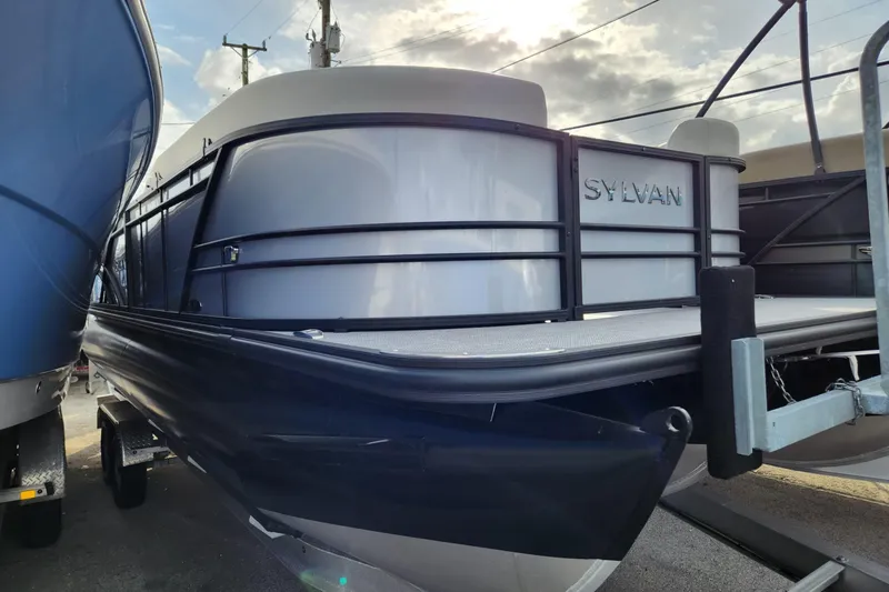 The Image of 2023 Sylvan X5 pontoon boat displayed outdoors under a cloudy sky. - 1