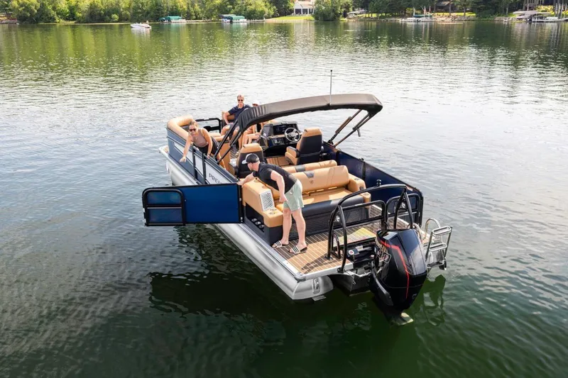 Slide: The Image of 2026 Premier 270 Intrigue RF pontoon boat on a serene lake with passengers. - 9