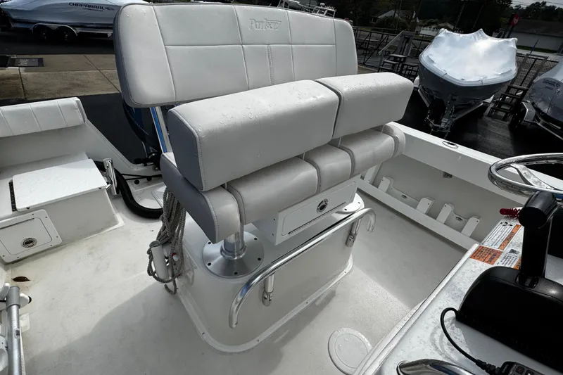Slide: The Image of 2021 Parker 2100 Center Console boat interior with white seating and steering area. - 23