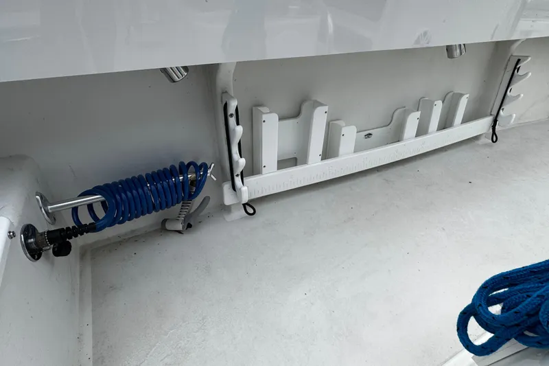 Slide: The Image of Interior of 2021 Parker 2100 Center Console boat with fishing rod holders and coiled hose. - 34