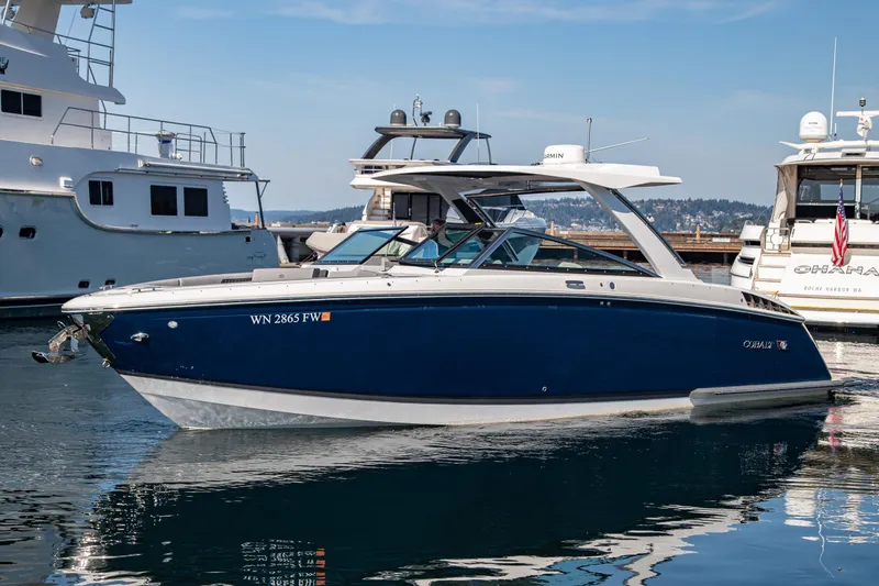 Slide: The Image of 2023 Cobalt R33 boat docked in marina, sleek design, blue and white exterior. - 13