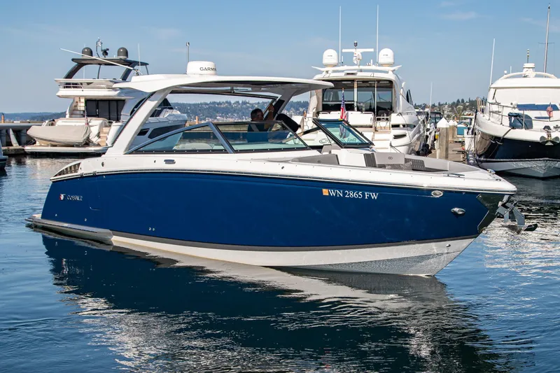 Slide: The Image of 2023 Cobalt R33 boat docked in marina, surrounded by other yachts. - 14