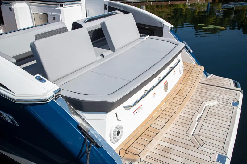 Slide: The Image of 2023 Cobalt R33 boat with sleek seating and wooden deck by the water. - 15