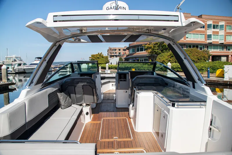 Slide: The Image of 2023 Cobalt R33 boat interior with sleek seating and modern amenities at a marina. - 16