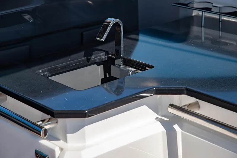 Slide: The Image of Sleek black countertop with modern faucet on 2023 Cobalt R33 boat. - 22