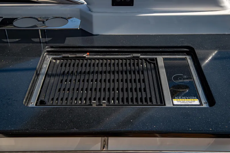 Slide: The Image of Built-in Kenyon grill on 2023 Cobalt R33 boat, featuring sleek black countertop design. - 23