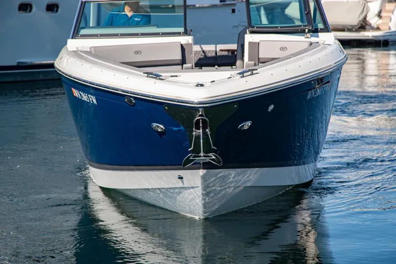 Slide: The Image of 2023 Cobalt R33 boat on water, front view, sleek blue and white design. - 3