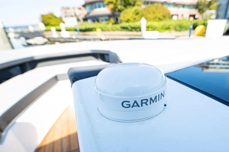 Slide: The Image of 2023 Cobalt R33 boat with Garmin navigation system, docked near waterfront homes. - 44