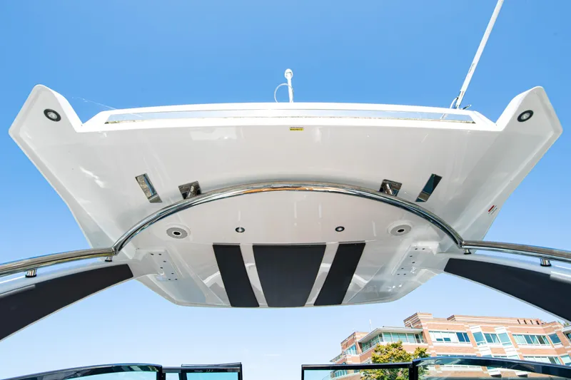 Slide: The Image of 2023 Cobalt R33 boat with sleek design, viewed from below against clear blue sky. - 45