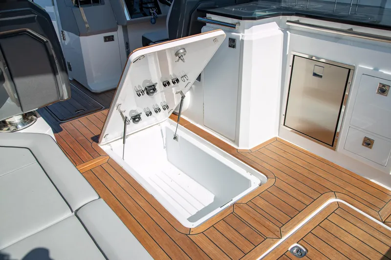 Slide: The Image of 2023 Cobalt R33 boat interior with open storage compartment on teak deck. - 47
