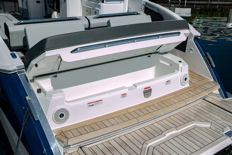 Slide: The Image of 2023 Cobalt R33 boat with open storage compartment on teak deck. - 49