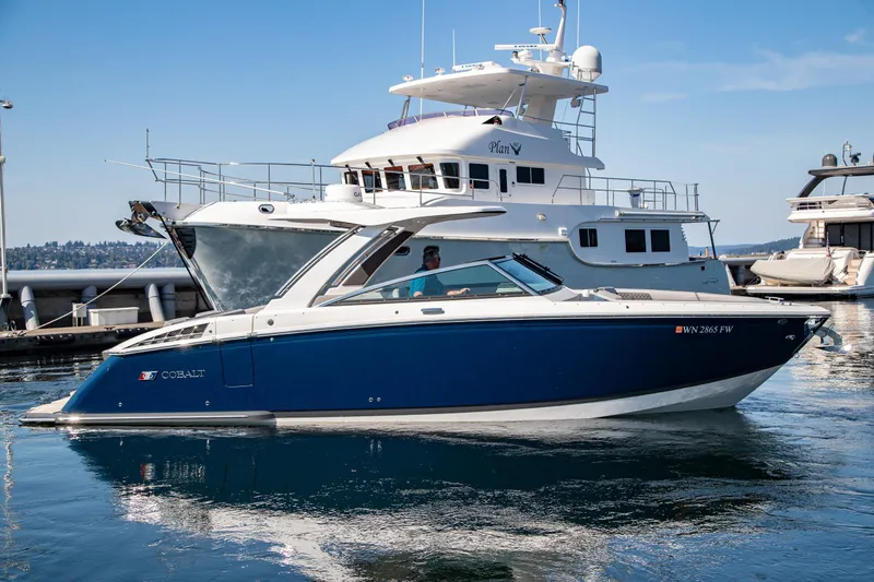 Slide: The Image of 2023 Cobalt R33 boat docked in a marina under clear blue skies. - 5