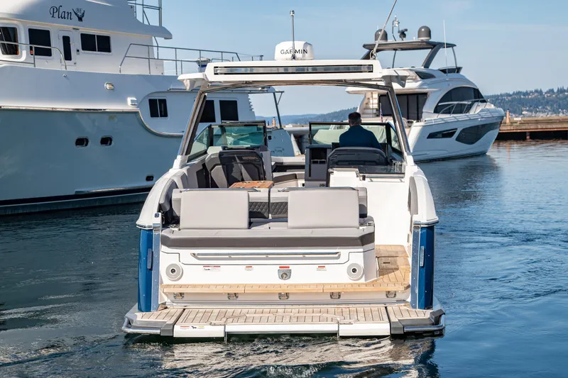Slide: The Image of 2023 Cobalt R33 boat docked, rear view, with luxury yachts in the background. - 9