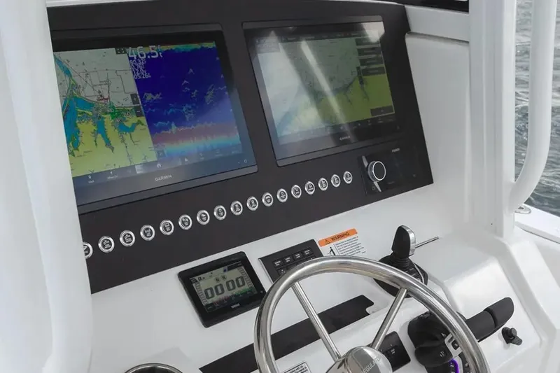 Slide: The Image of 2026 Regulator 28 Forward Seating boat dashboard with dual Garmin displays and steering wheel. - 3