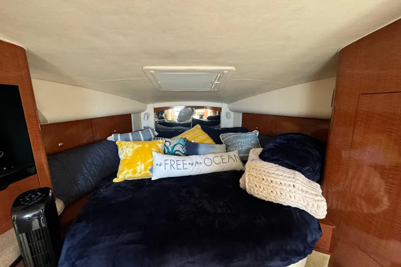 Slide: The Image of Cozy cabin interior of 2003 Sea Ray 320 Sundancer with plush bedding and decorative pillows. - 10