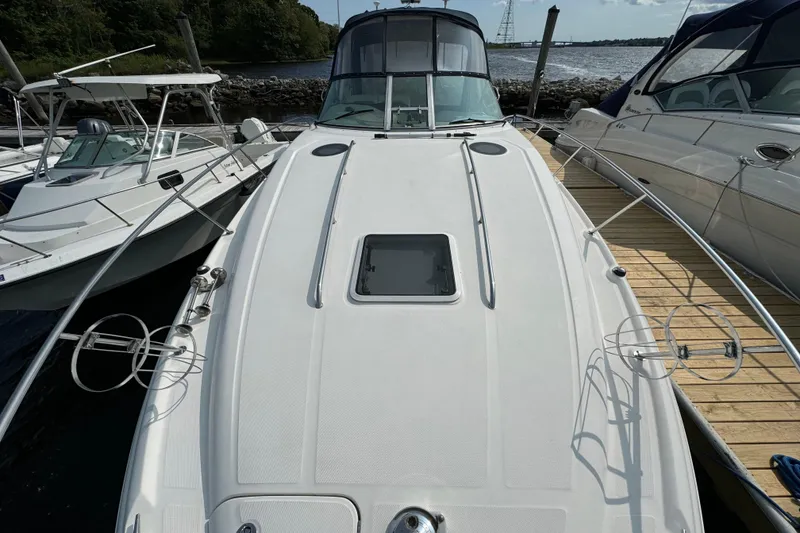 Slide: The Image of 2003 Sea Ray 320 Sundancer docked, showcasing sleek design and spacious deck. - 14
