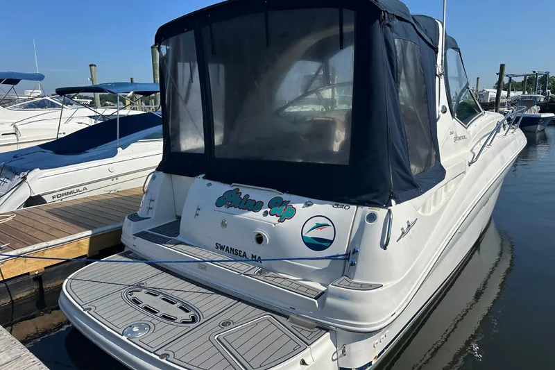 Slide: The Image of 2003 Sea Ray 320 Sundancer docked at marina, rear view with canopy. - 2