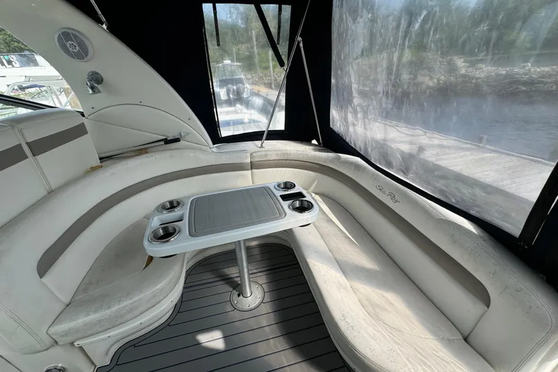 Slide: The Image of 2003 Sea Ray 320 Sundancer interior with curved seating and table, dock view. - 3