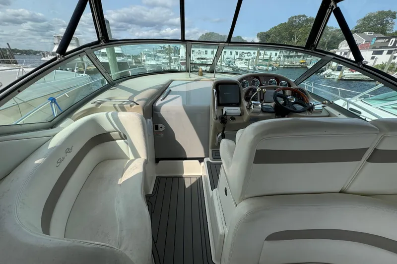 Slide: The Image of 2003 Sea Ray 320 Sundancer cockpit with steering wheel and seating, docked at marina. - 7