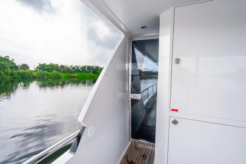 Slide: The Image of Side view of 2020 Horizon FD80 yacht with river and greenery in background. - 56