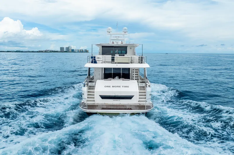 Slide: The Image of Luxury Horizon FD80 yacht cruising on open sea, 2020 model, with city skyline in background. - 76