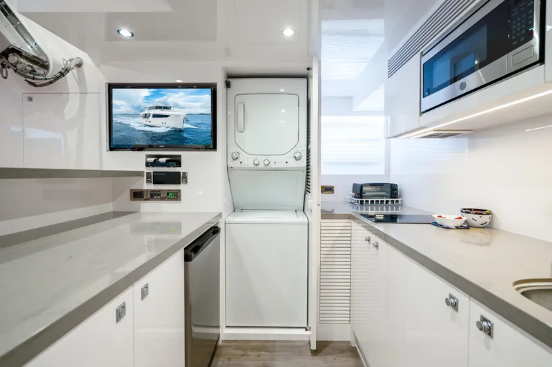 Slide: The Image of Modern yacht kitchen with appliances, TV, and stacked washer-dryer. Horizon FD80, 2020 model. - 83