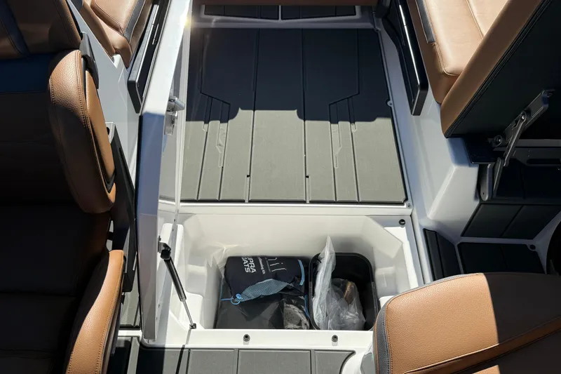 Slide: The Image of 2026 Supra SA 550 boat interior with storage compartment and brown seating. - 23