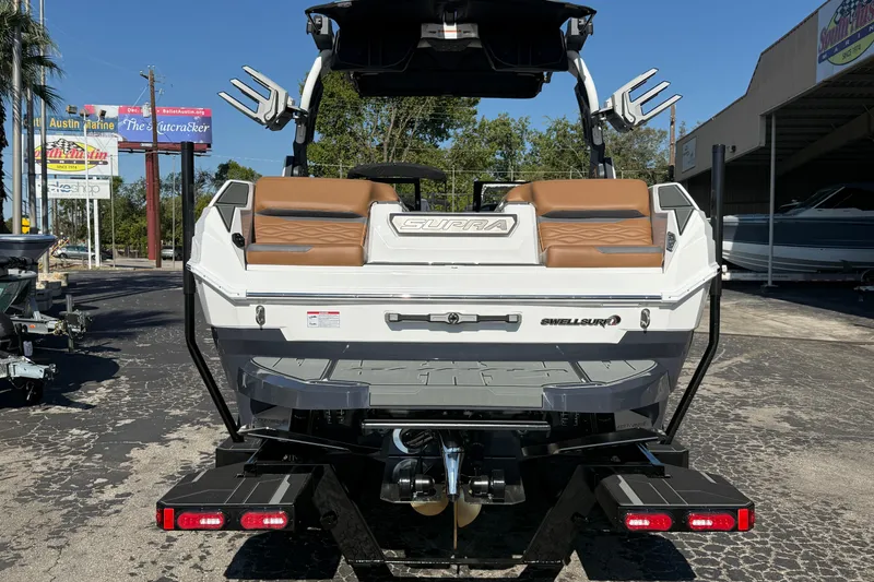 Slide: The Image of 2026 Supra SA 550 boat rear view with brown seating and Swell Surf system. - 4