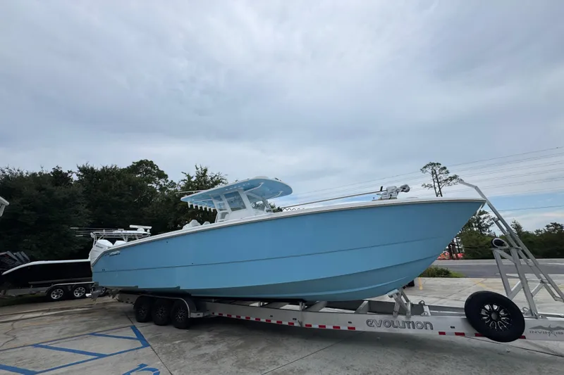 Slide: The Image of 2025 Invincible 40 Catamaran in light blue on a trailer, parked outdoors. - 10