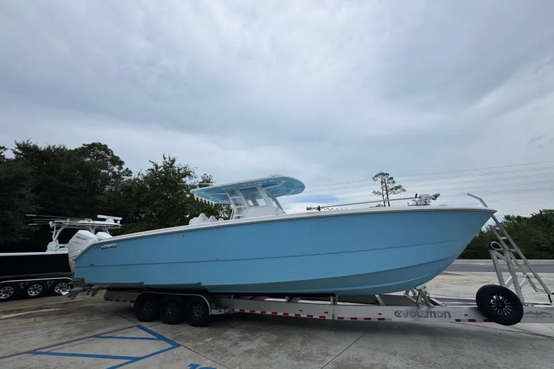Slide: The Image of 2025 Invincible 40 Catamaran in light blue on a trailer, parked outdoors. - 11