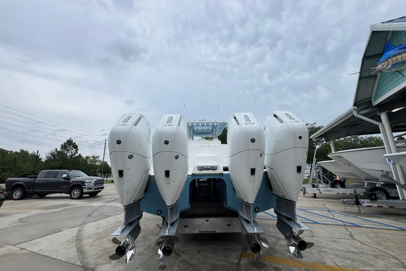 Slide: The Image of 2025 Invincible 40 Catamaran with quad outboard engines, parked outdoors. - 17