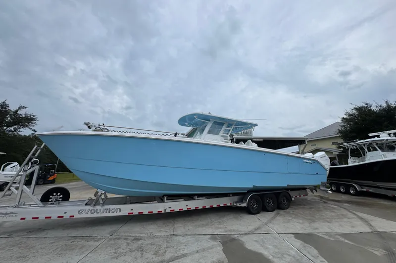 Slide: The Image of 2025 Invincible 40 Catamaran in light blue on a trailer, parked outdoors. - 2