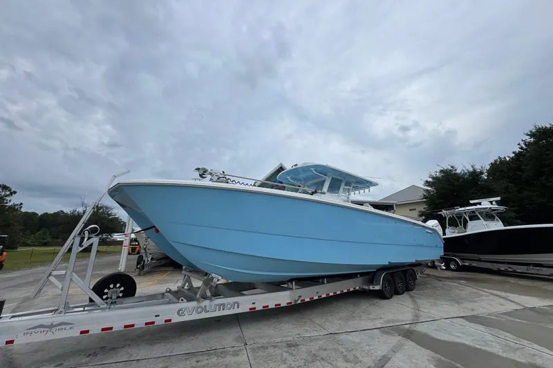 Slide: The Image of 2025 Invincible 40 Catamaran in light blue on trailer, parked outdoors. - 3