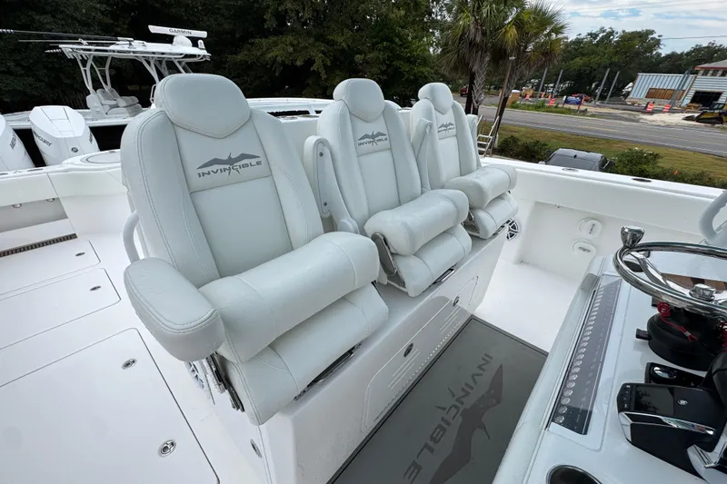 Slide: The Image of 2025 Invincible 40 Catamaran with luxurious white seating and modern helm controls. - 42