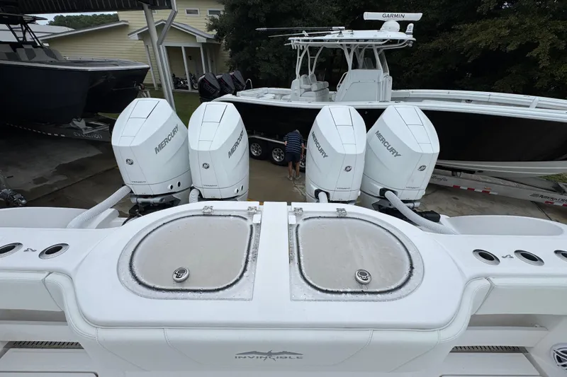 Slide: The Image of 2025 Invincible 40 Catamaran with four Mercury outboard engines, docked in a marina. - 49