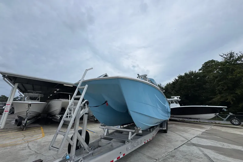 Slide: The Image of 2025 Invincible 40 Catamaran on trailer, parked outdoors under cloudy sky. - 5